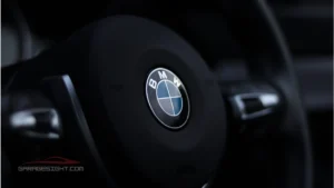 Close-up of BMW iX2 steering wheel with BMW badge, showcasing premium cabin design and advanced driving features.