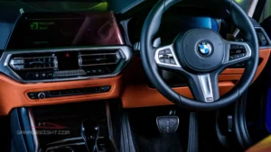 BMW 330e interior view with premium dashboard, digital touchscreen, multifunction steering wheel, and luxury cabin features.