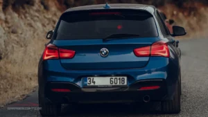 BMW M135i rear view featuring LED taillights, dual exhaust outlets, sporty hatchback styling, and dynamic road presence.
